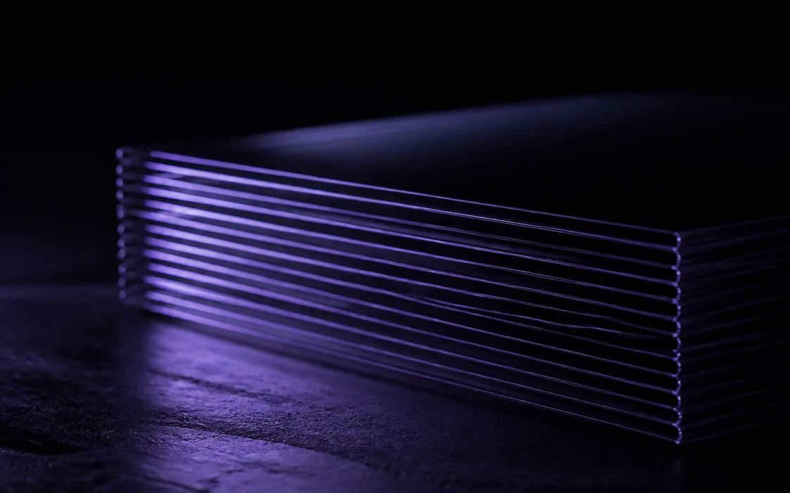 A stack of translucent sheets seen edge on, lit so each thin edge glows